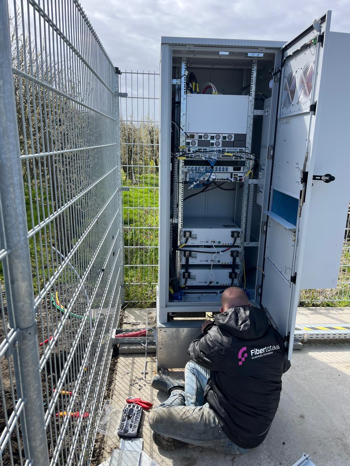Fibertotaal-monteur aan het werk bij een apparatuurkast