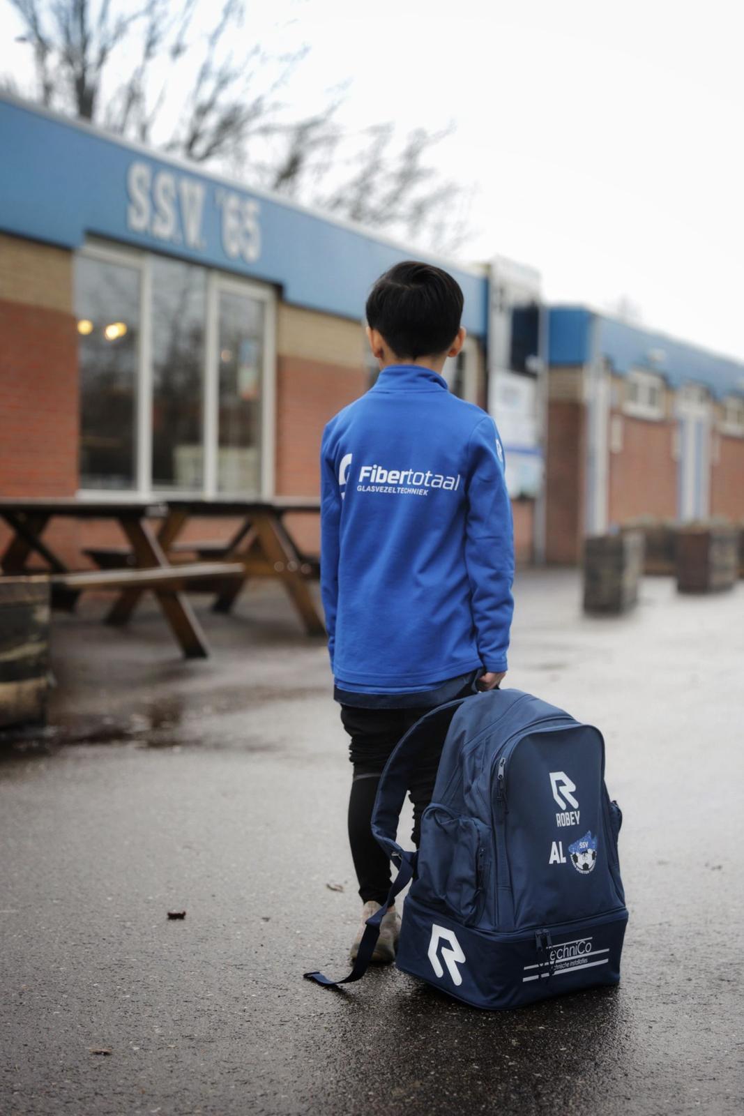 Jonge speler met Fibertotaal-vest en tas